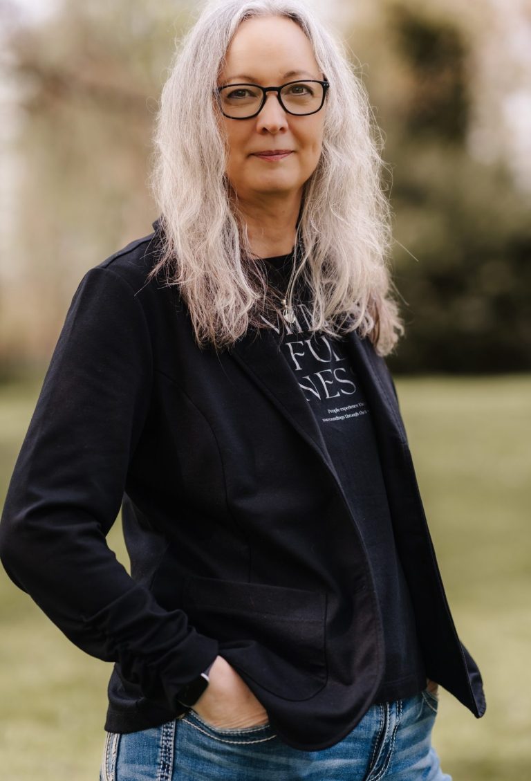 Die Hypnosetherapeutin Anett Bartelt, lächelnd in einem urbanen, herbstlichen Umfeld.